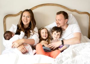 Natural in-home newborn session with family photographed cuddled in bed