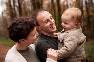 Mother and Father cuddling their baby in the forest