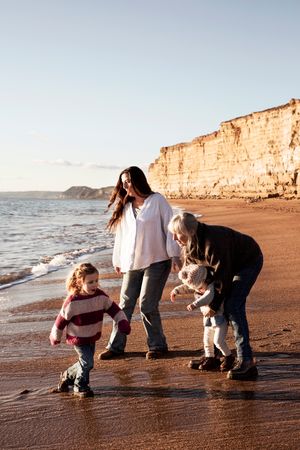 Alternative family photograph with family running in and out of the waves