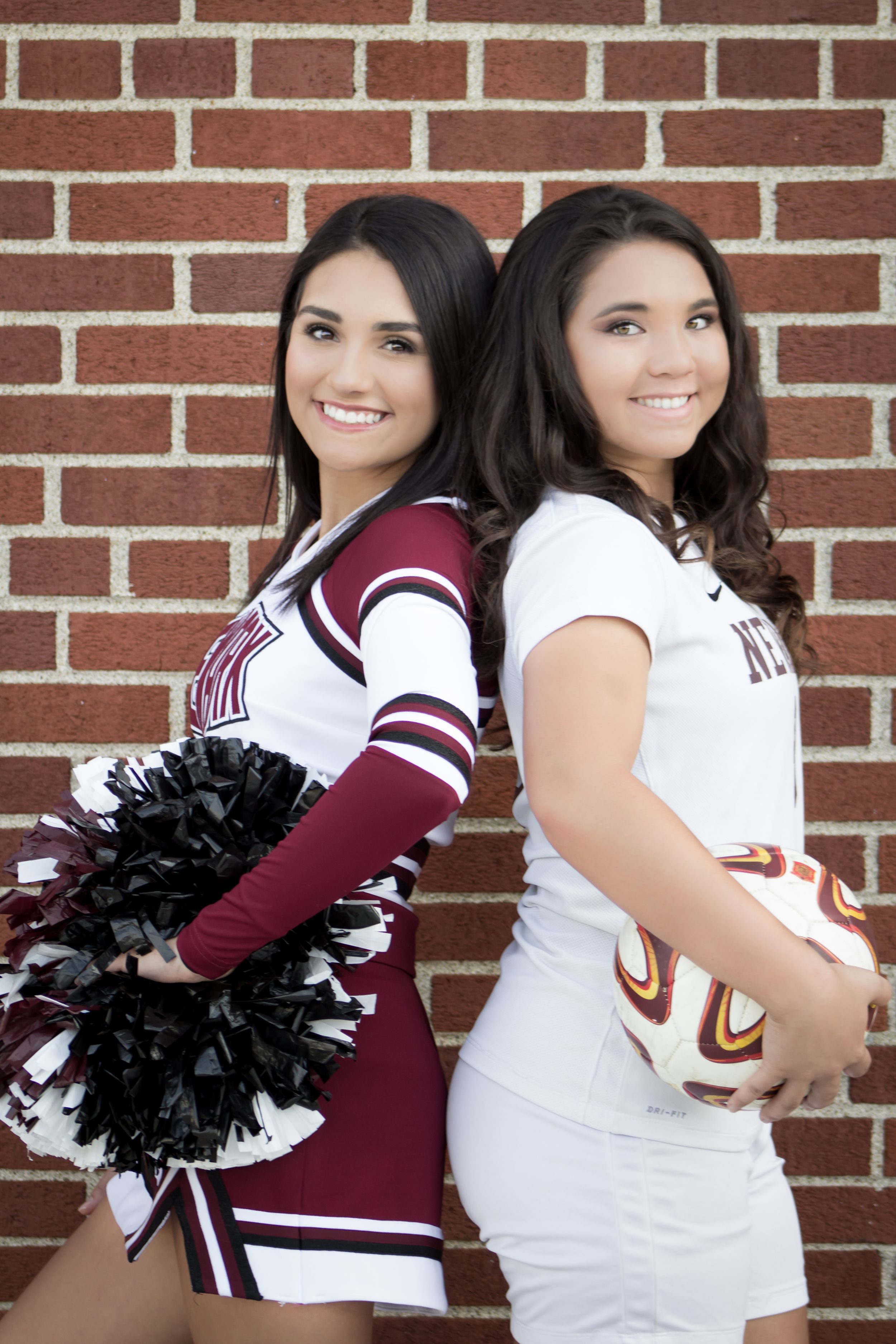 Two Newark high school girls pose back-to-back, one in cheer uniform and one in soccer gear.