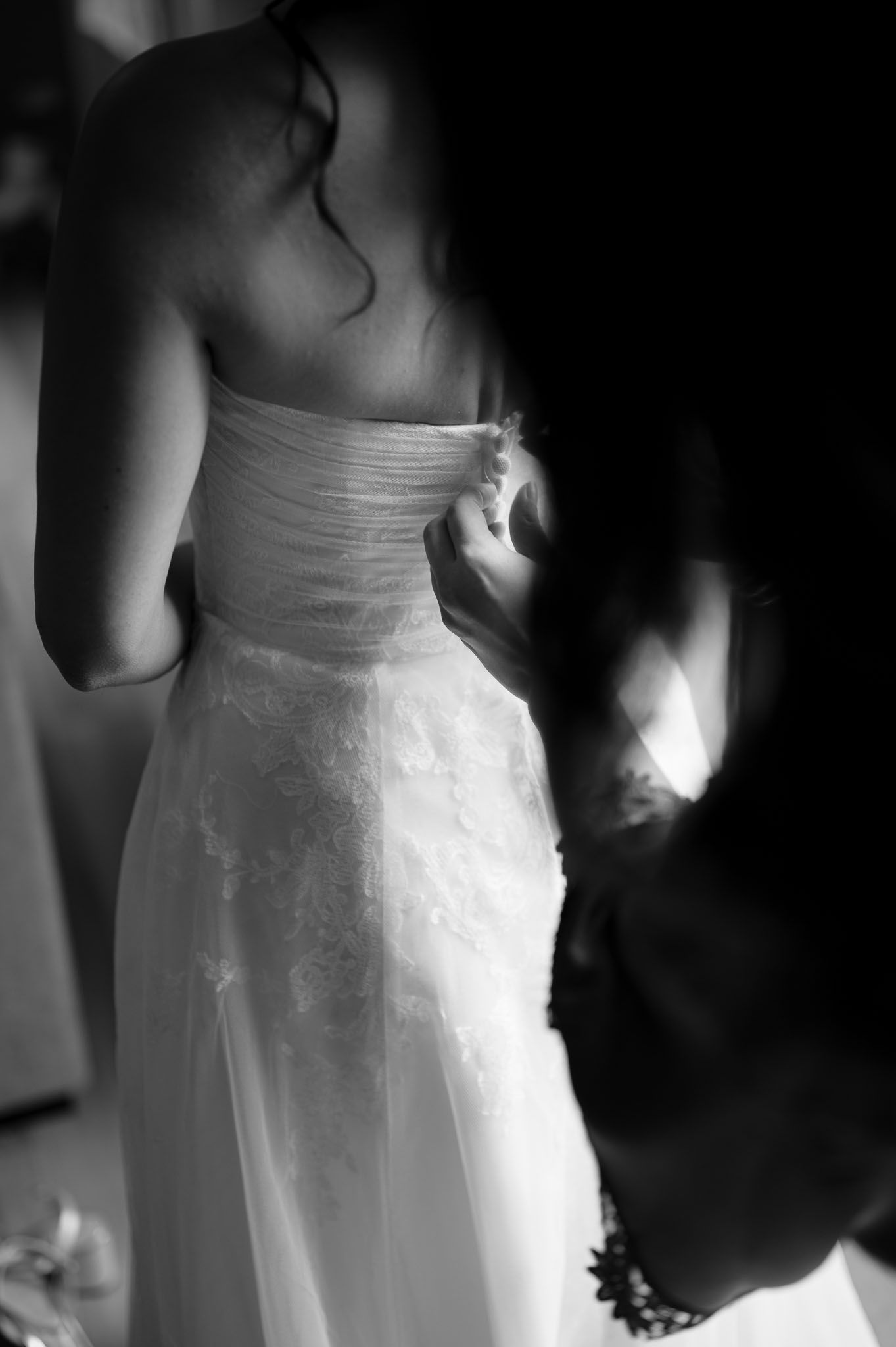 Artistic black and white detail shot of bride's wedding dress bodice.