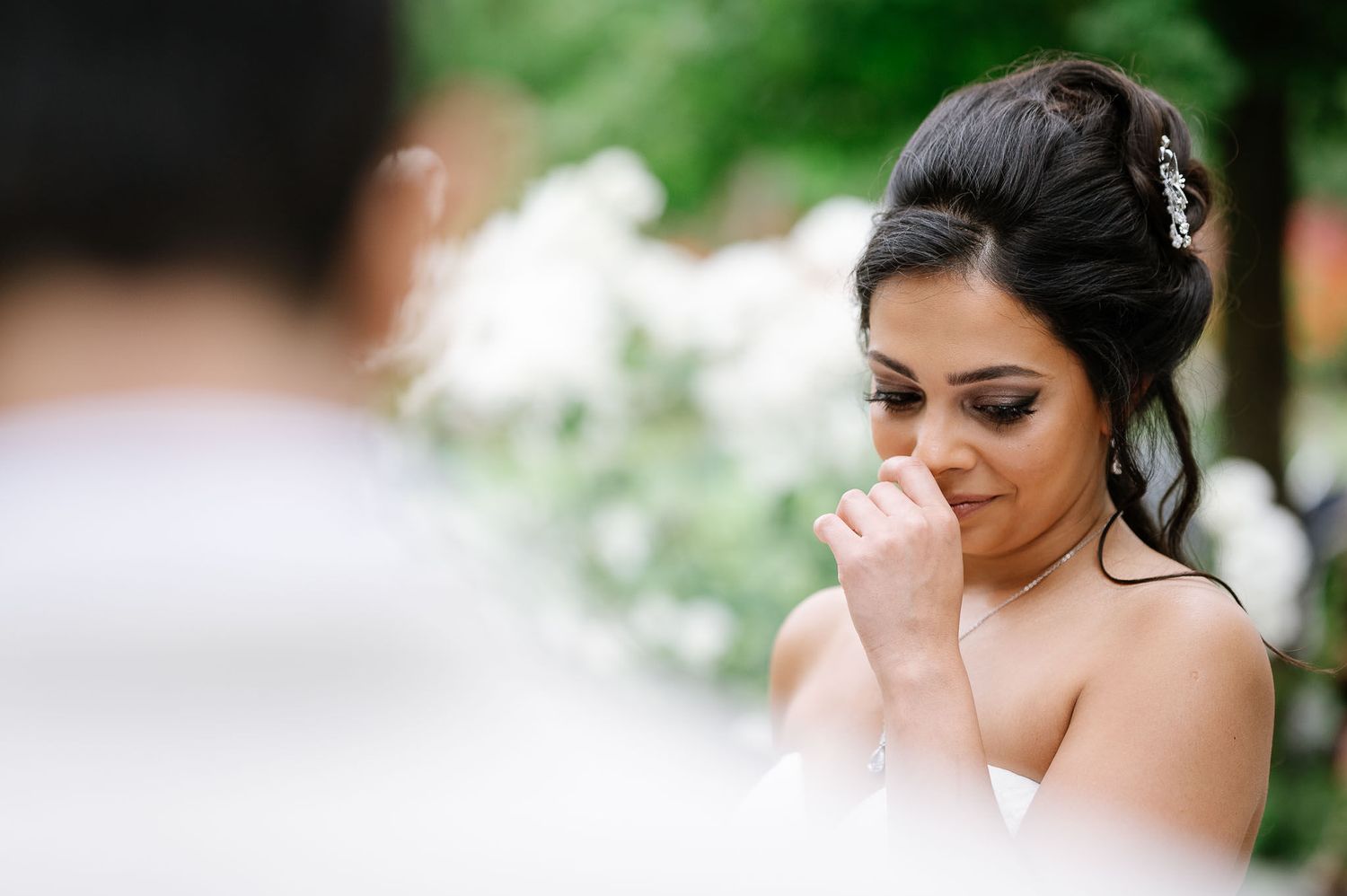 An emotional moment captured during a wedding ceremony outdoors.