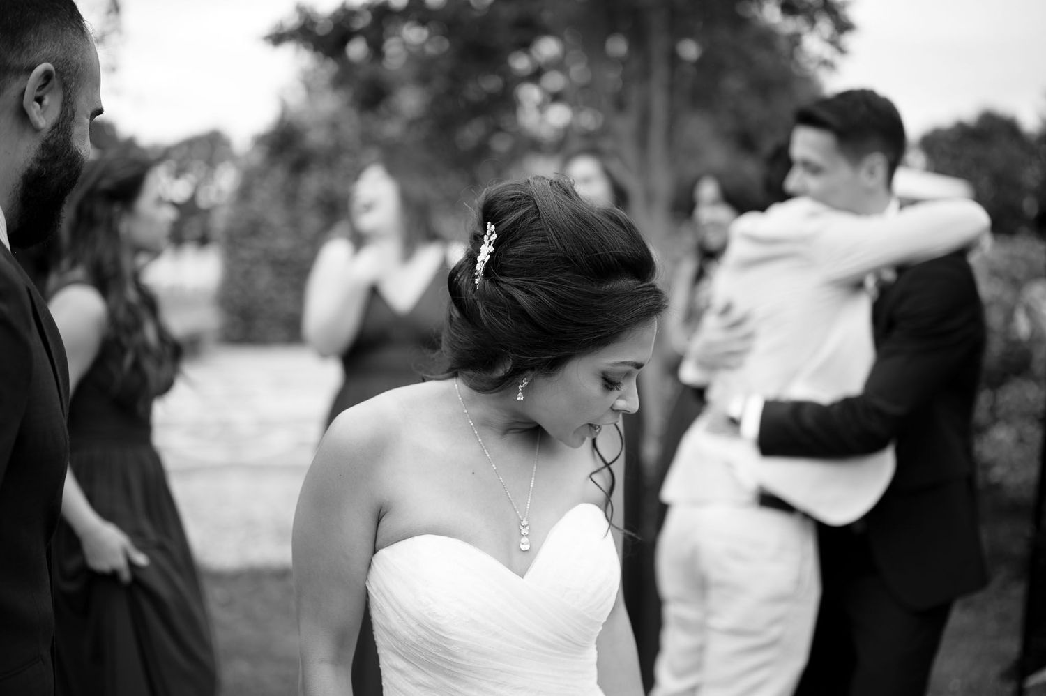 Black and white candid moment during outdoor wedding celebration.