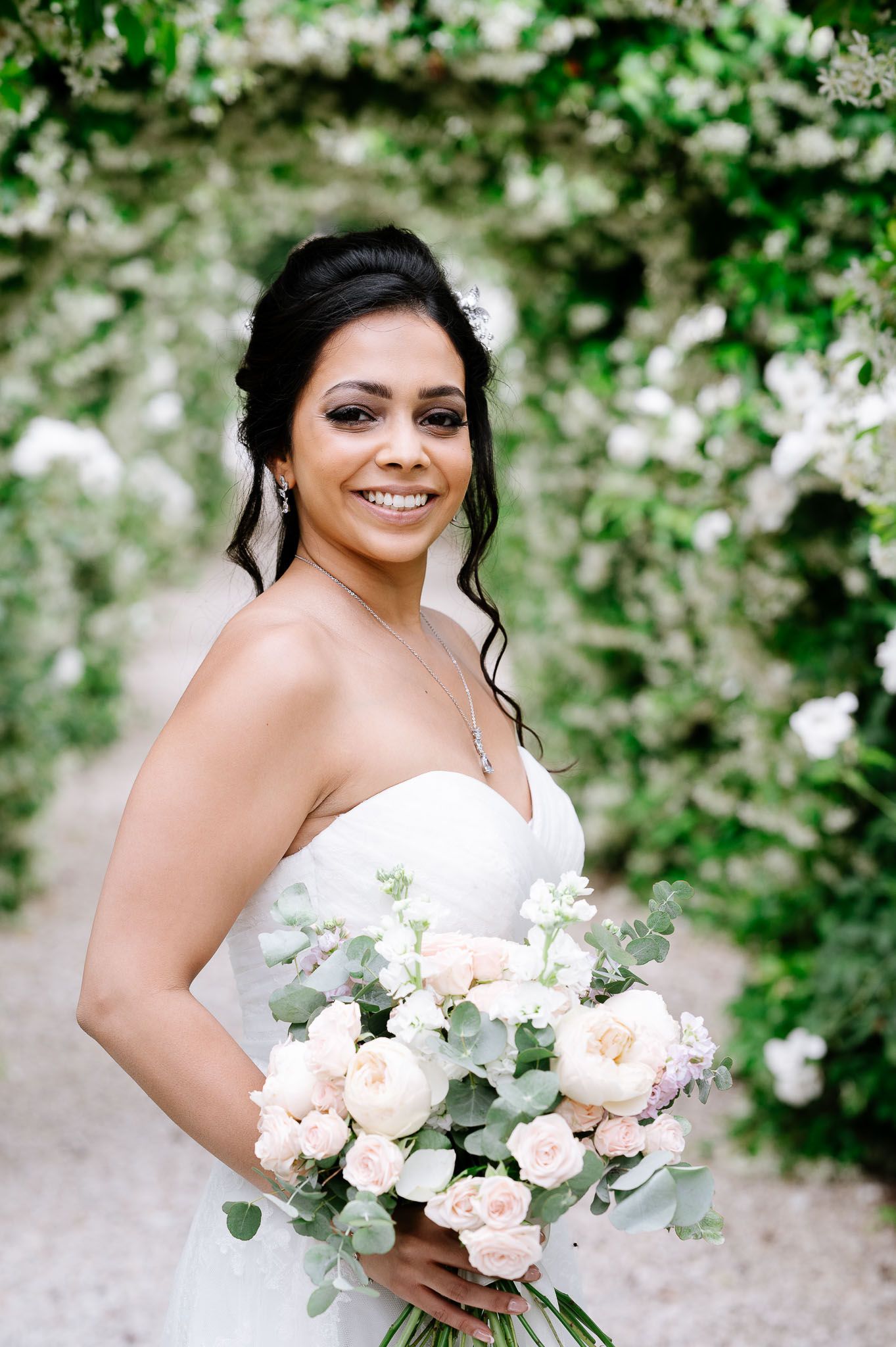 Beautiful wedding bouquet featuring blush roses and eucalyptus against a floral backdrop.