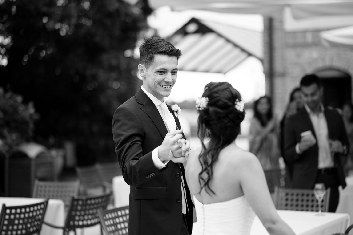 Black and white photo of a romantic first dance moment at an outdoor wedding reception.
