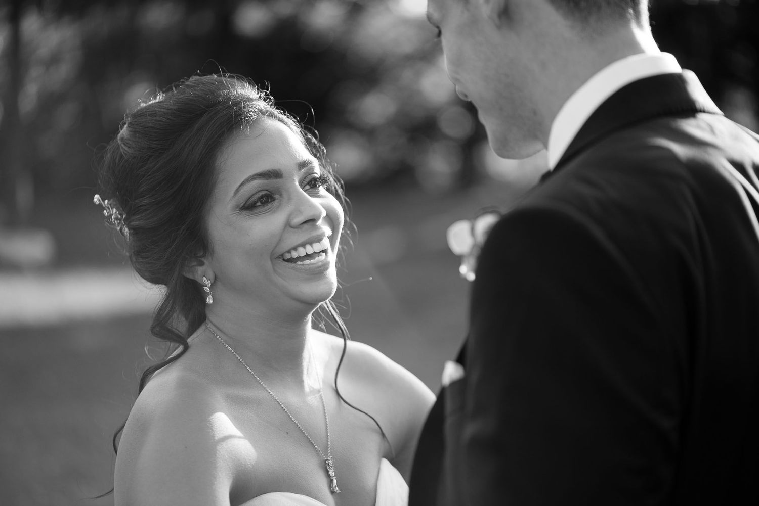 Black and white wedding portrait capturing a joyful moment between newlyweds.