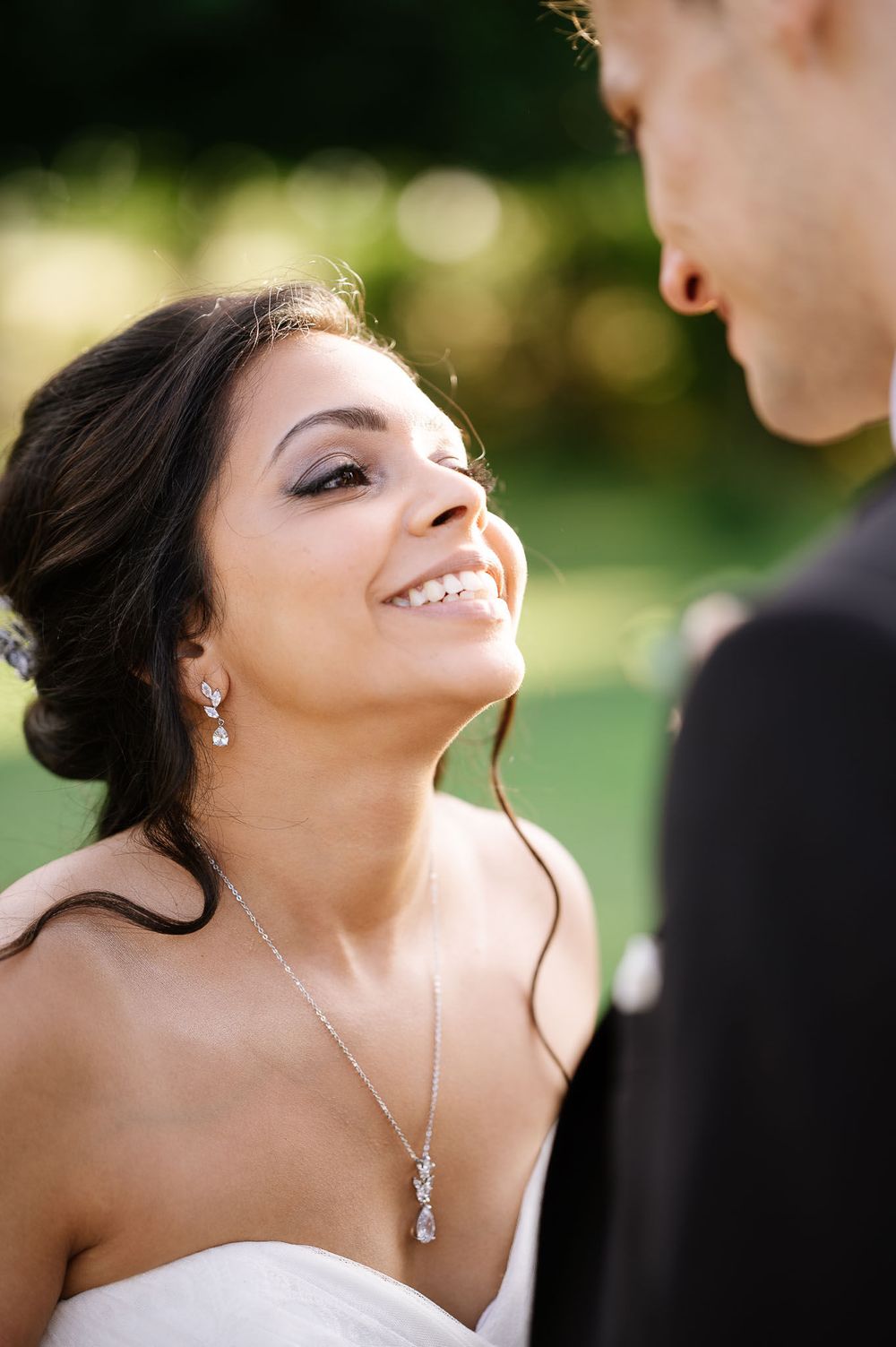 Close-up wedding portrait showcasing elegant bridal jewelry and makeup.