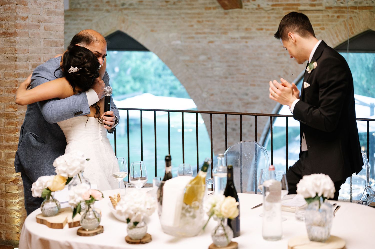 Emotional wedding moment with photographer capturing couple at reception table.
