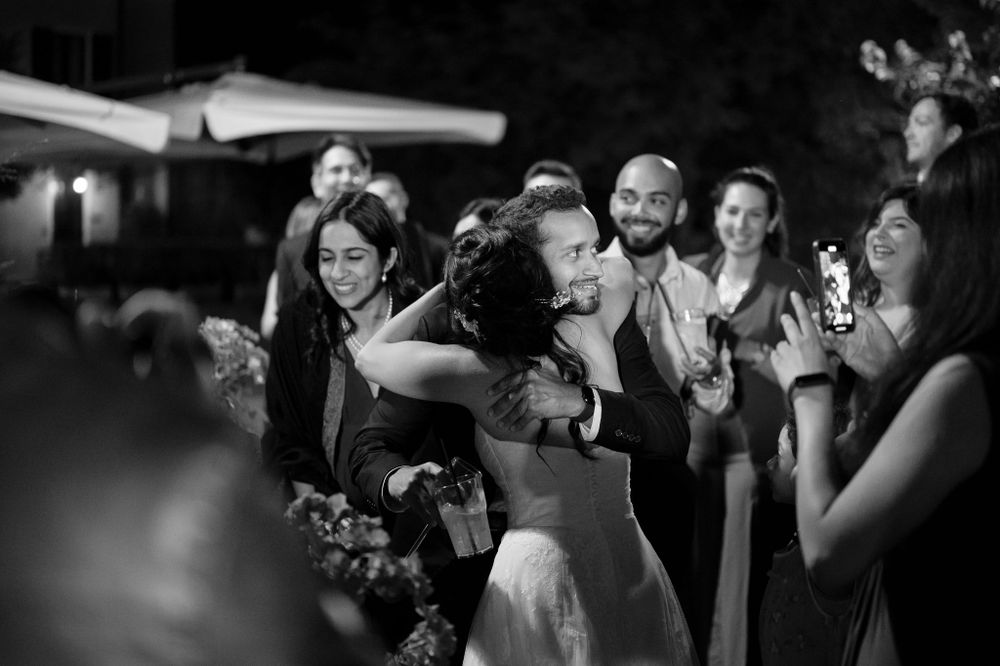 Black and white photo of wedding guests dancing and celebrating at reception.
