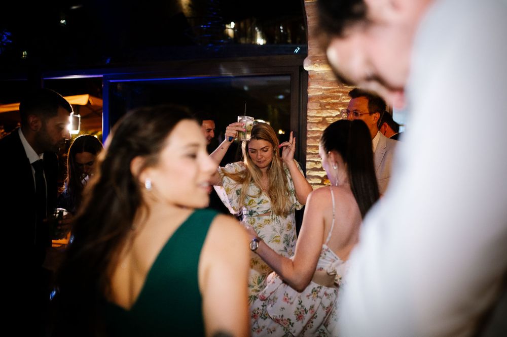 Guests dancing and celebrating at dimly lit indoor reception venue.