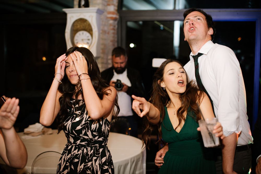 Party guests sing and dance enthusiastically during a nighttime celebration.