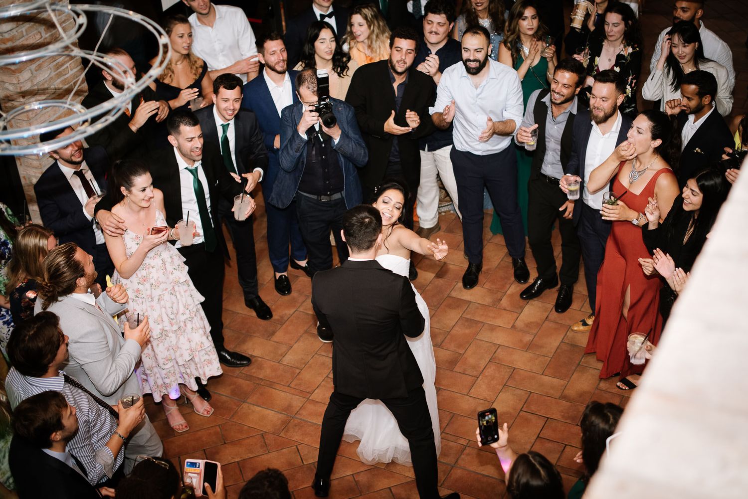 Overhead view of a wedding dance floor with guests forming a circle around the couple.