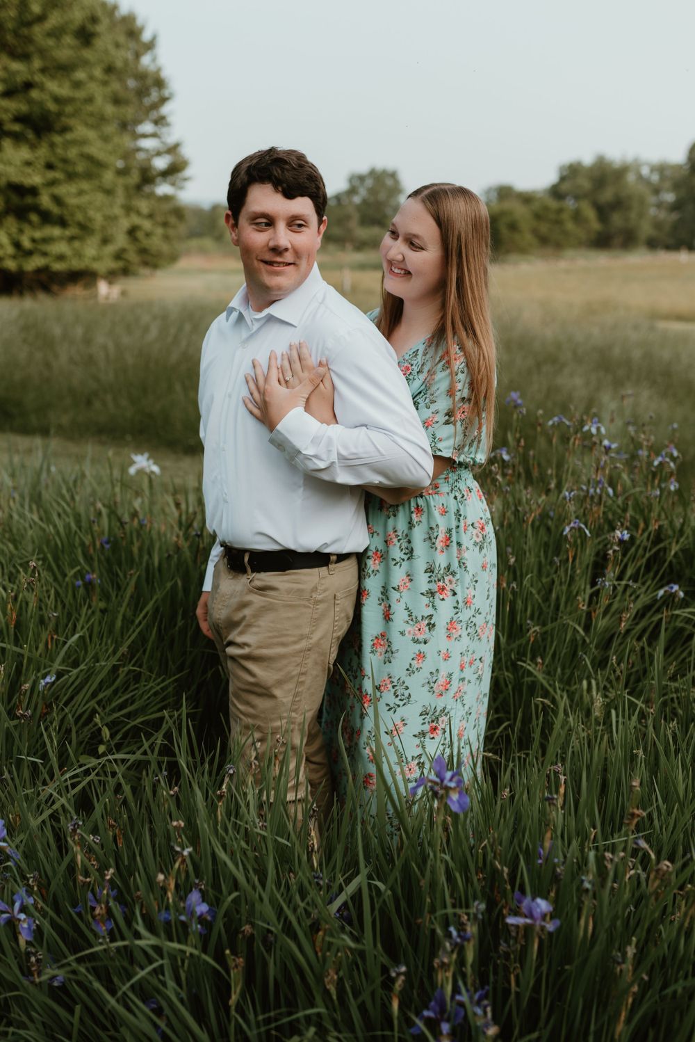 Playful couple photoshoot in field of purple iris flowers.
