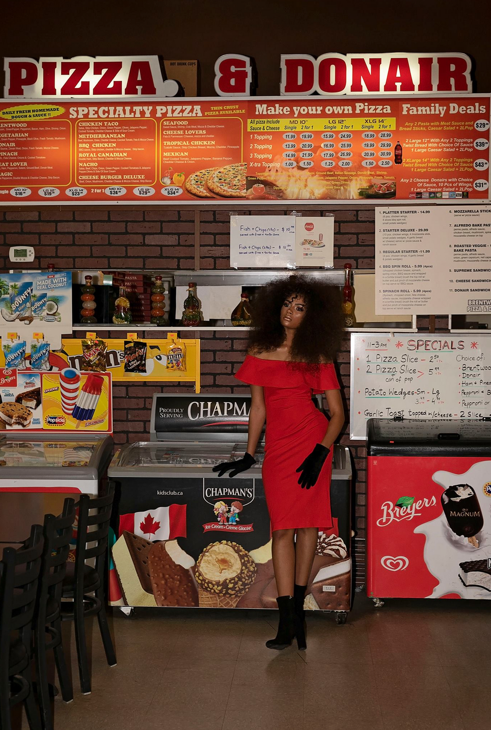 Interior of a pizza and donair restaurant showing menu board and counter area.