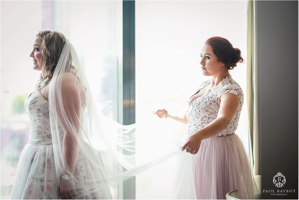 Two elegant wedding dresses photographed in soft window light.