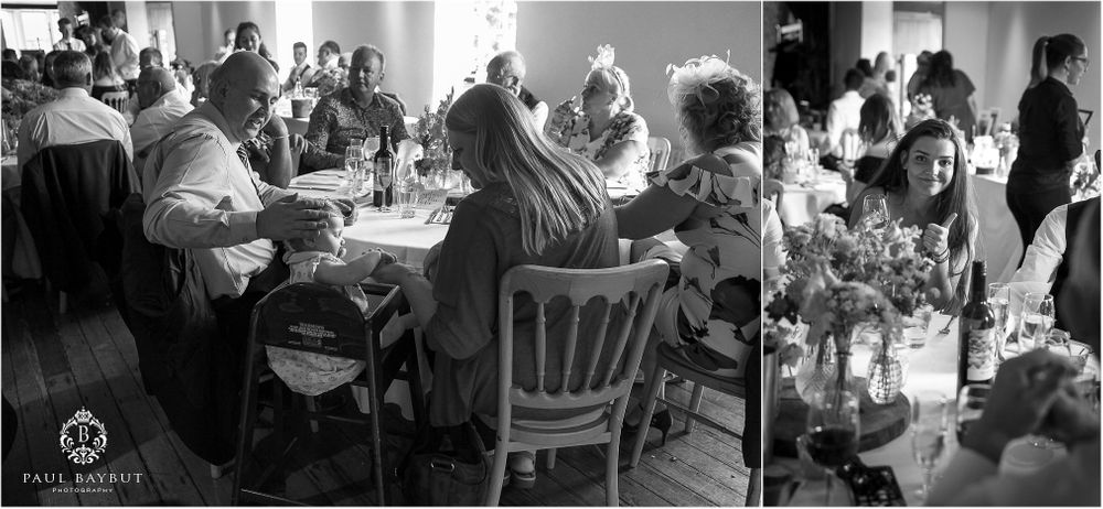 Black and white photo of wedding guests enjoying a reception meal.