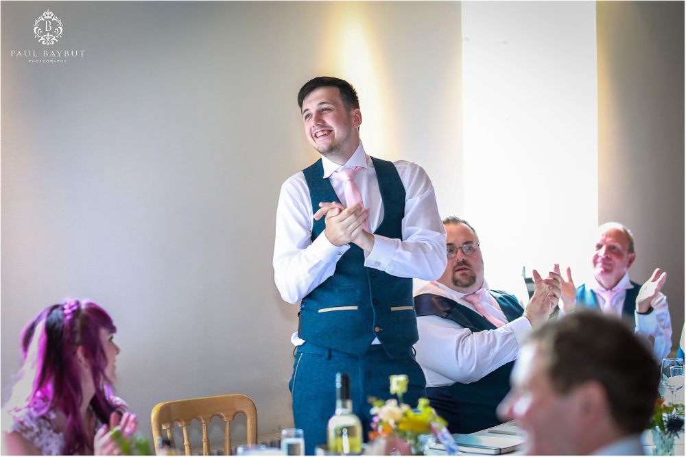 A lively wedding reception speech with guests laughing and enjoying the celebration.