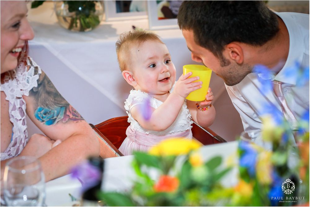 A sweet candid moment during a wedding reception with a young child enjoying refreshments.