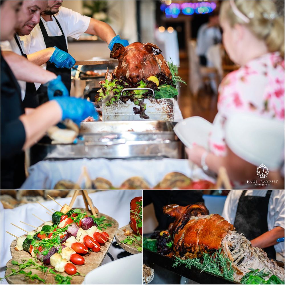 Delicious wedding reception buffet spread featuring roasted meats and fresh salads.