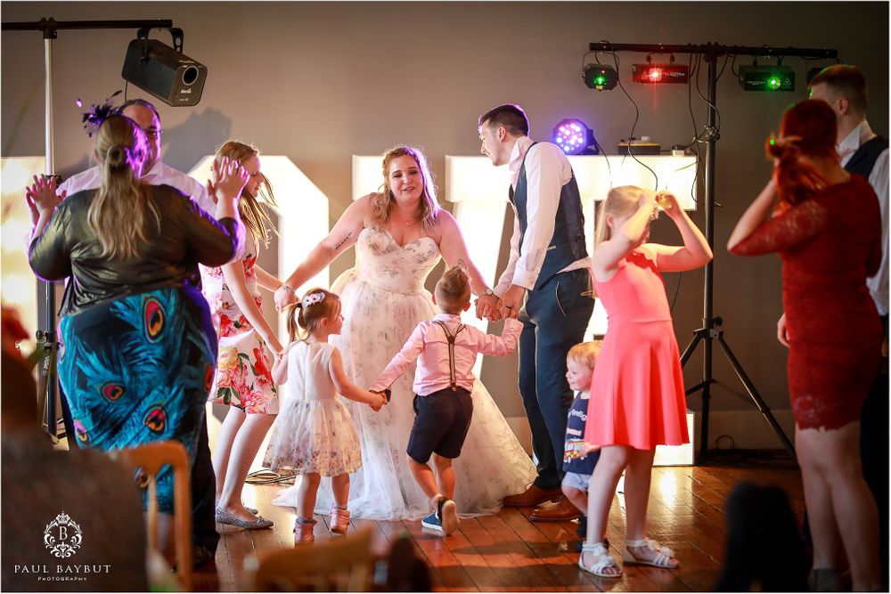 Wedding guests dancing and having fun at a lively reception party.