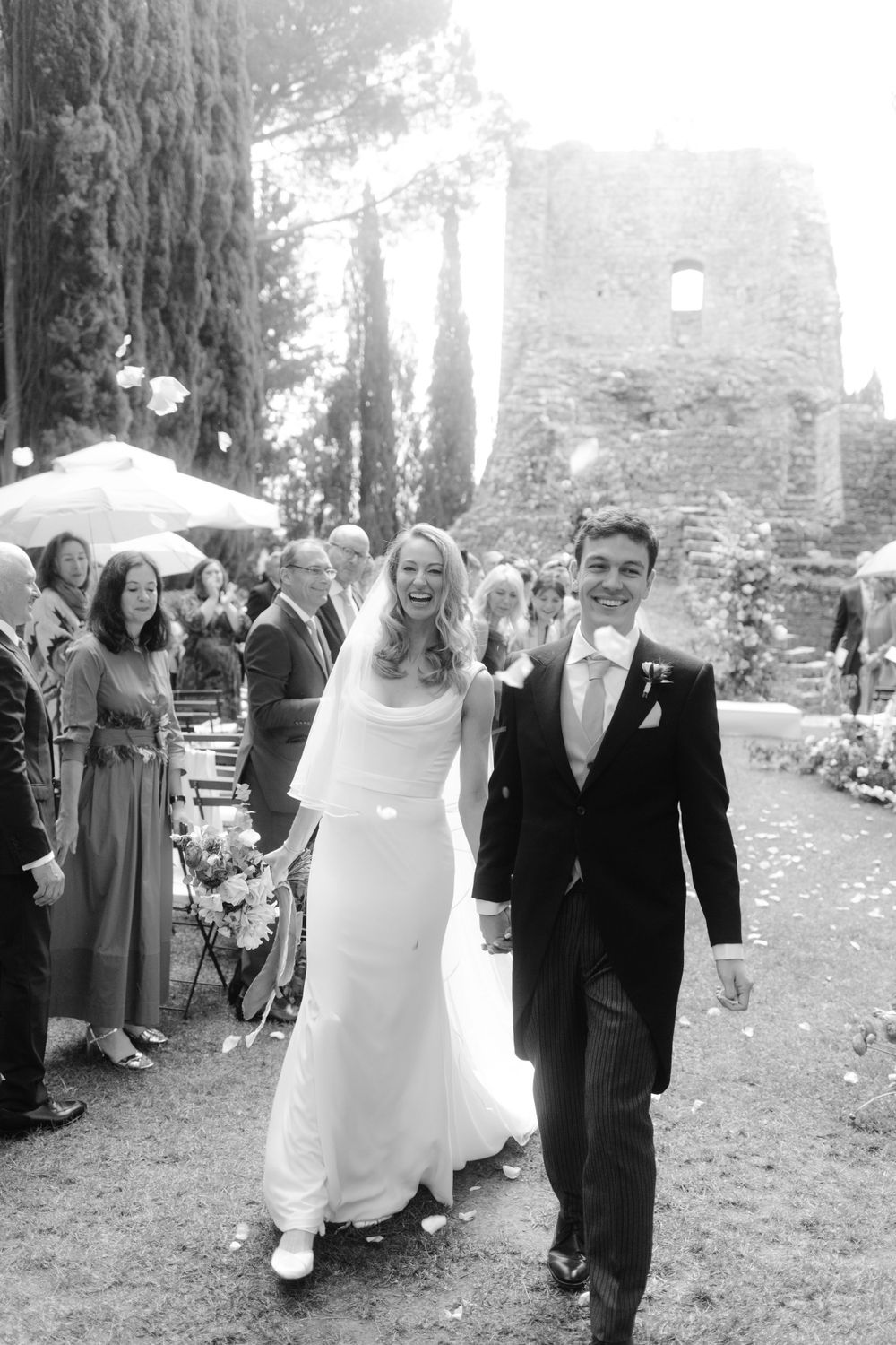 Happy newlyweds emerge from outdoor ceremony, smiling with joy
