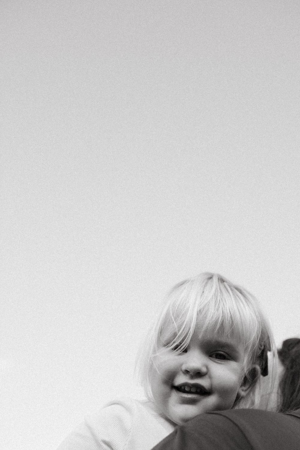 Black and white portrait of child smiling joyfully during family photoshoot in San Diego.