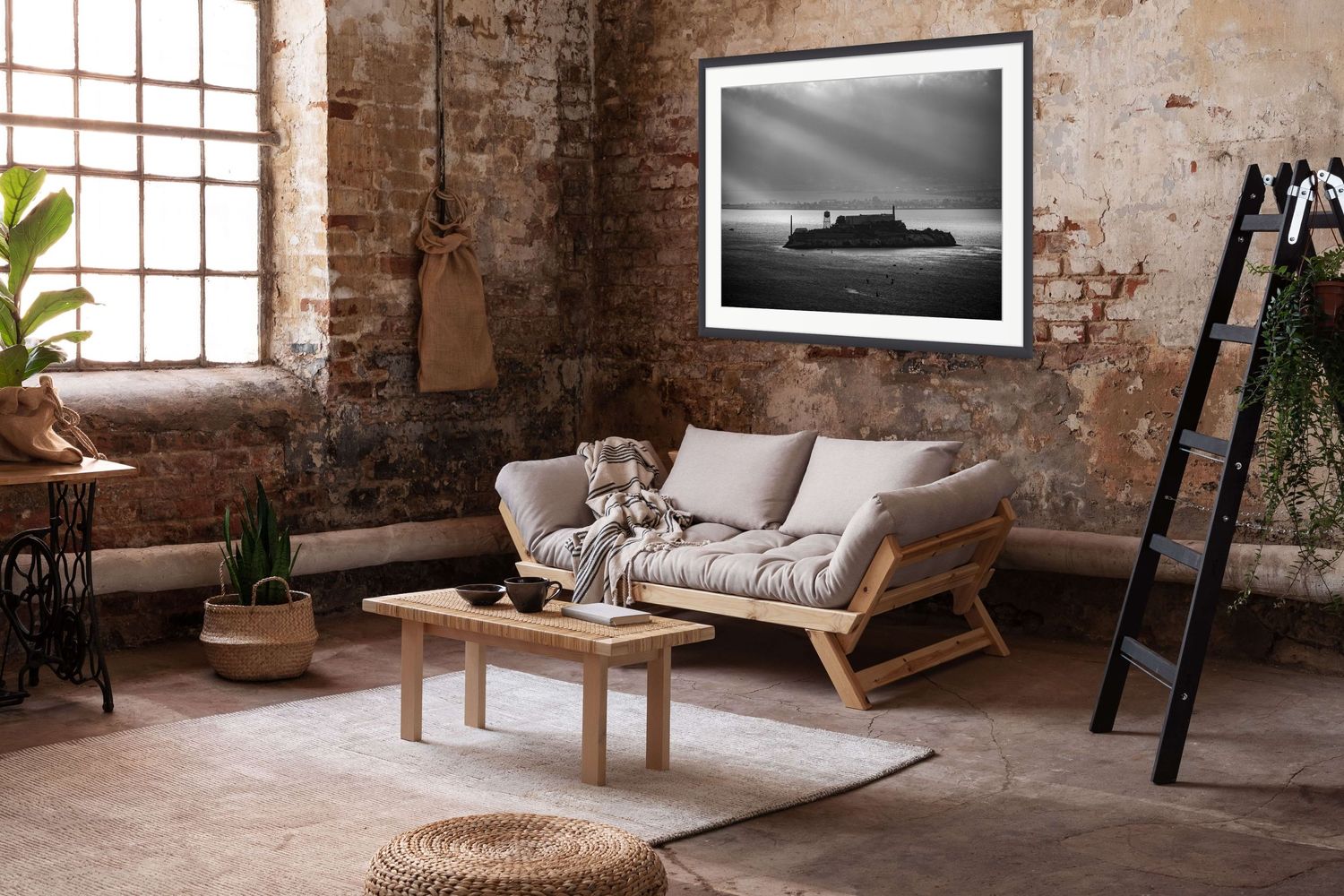 Industrial style living room with exposed brick walls, wooden furniture, and black and white coastal artwork.