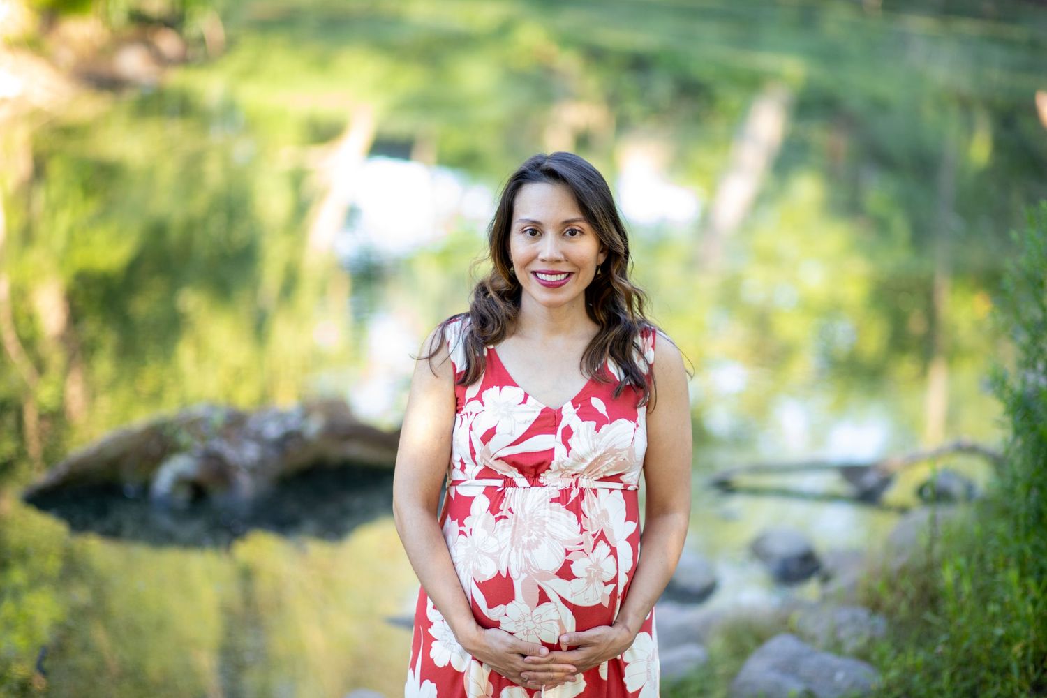 Outdoor portrait against blurred natural background near a stream.