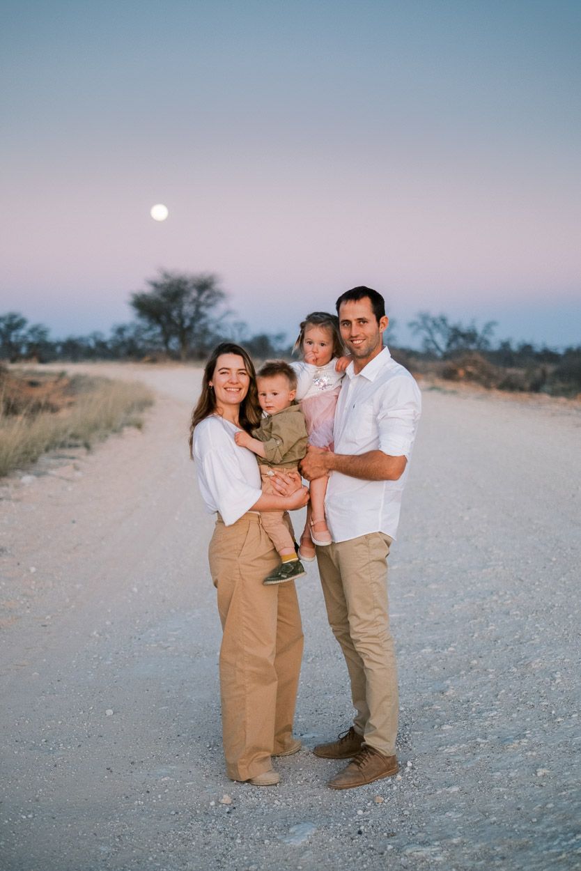 Family poses in a dirt road at sunset in the Molopo district.