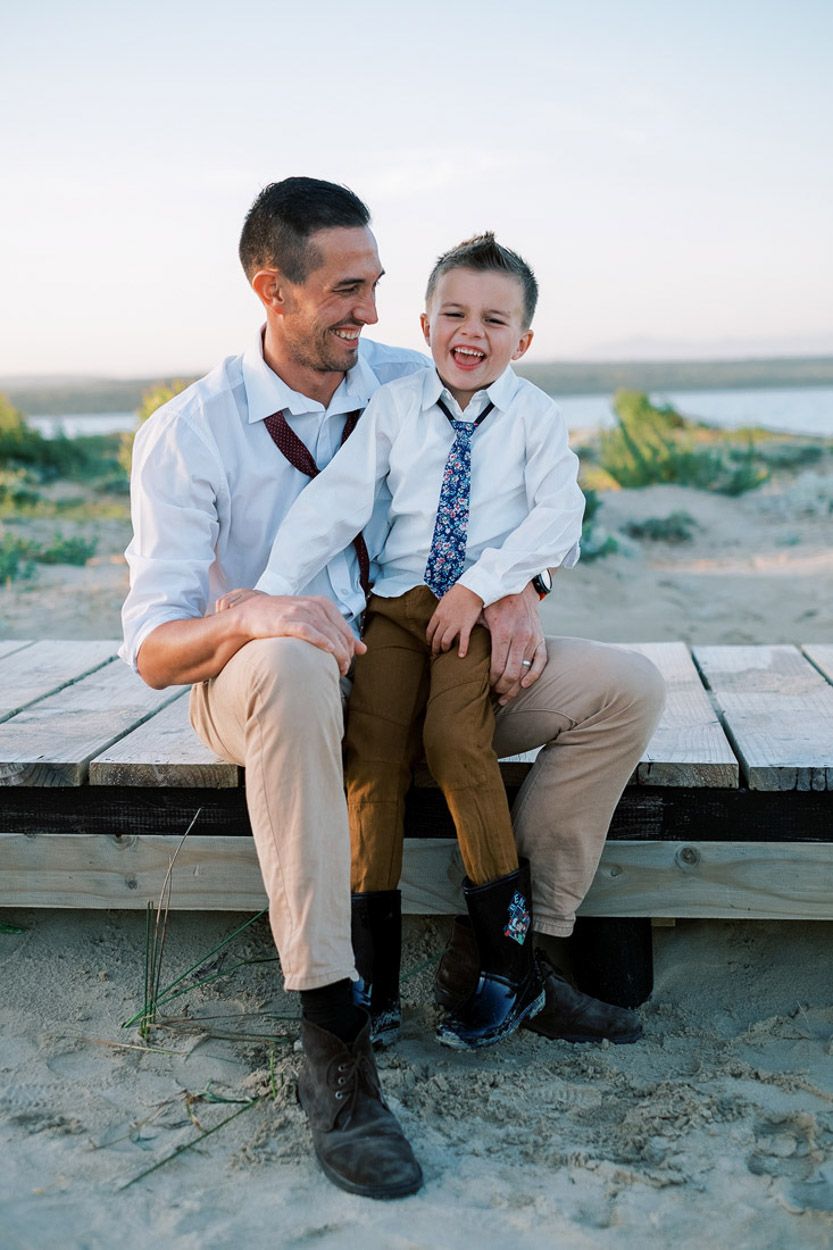 Father and son have a laugh on pier next to the beach, Jeffreys Bay.
