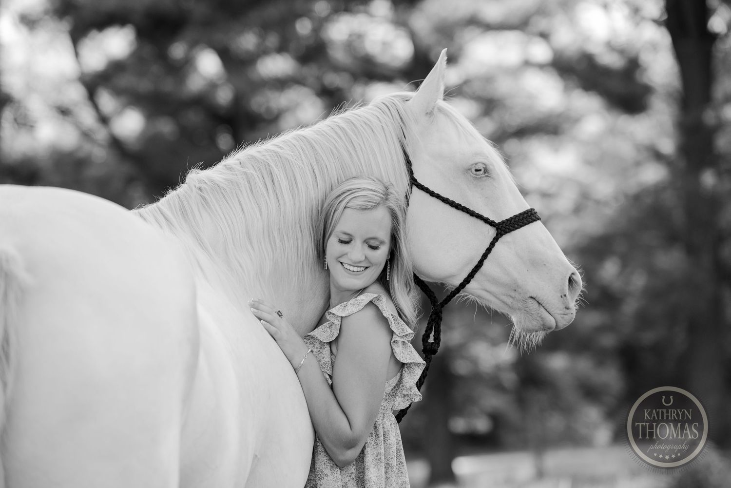 Elegant white horse and companion share tender black and white moment outdoors.