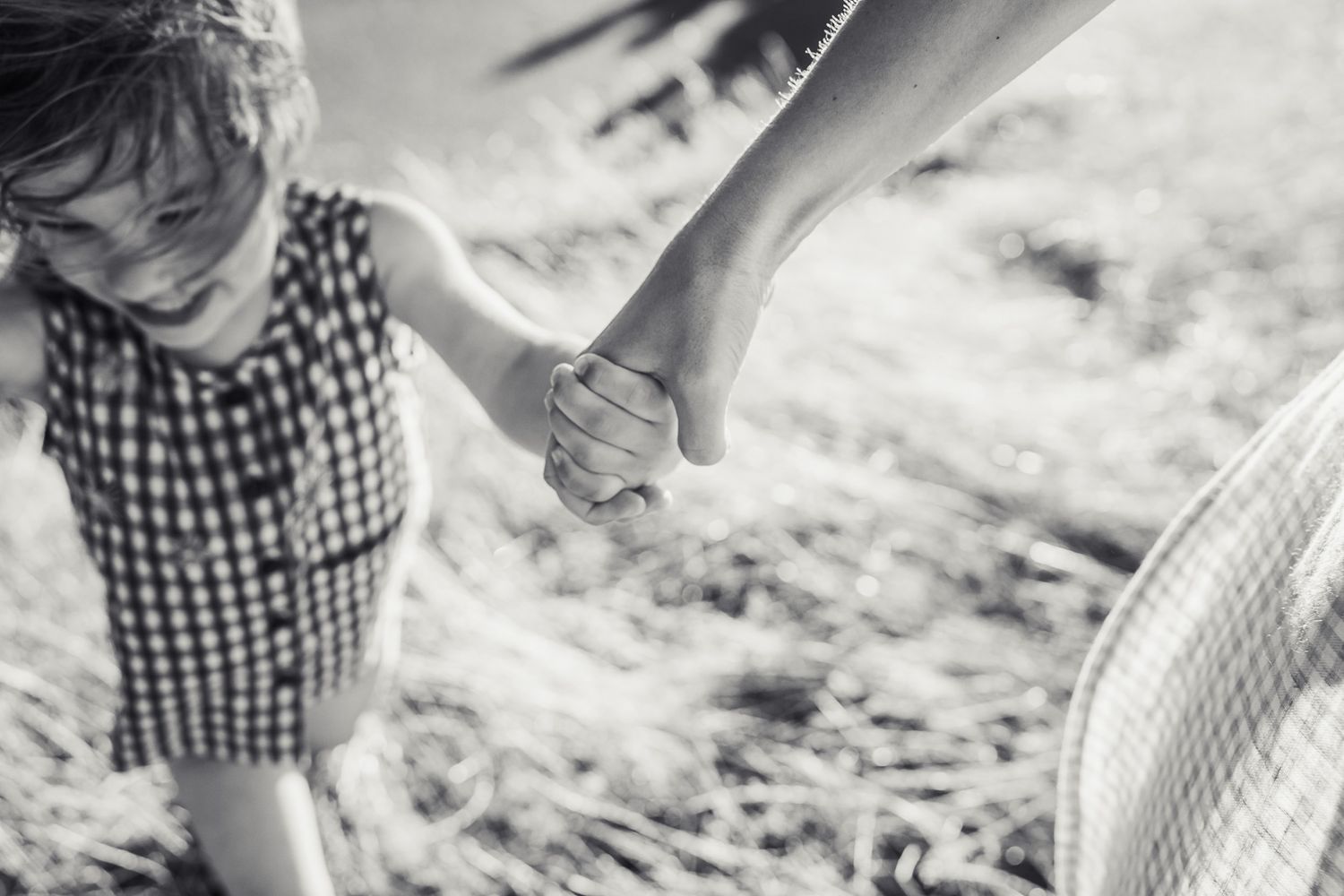 Black and white photo of mother holding daughters hand in Seattle.