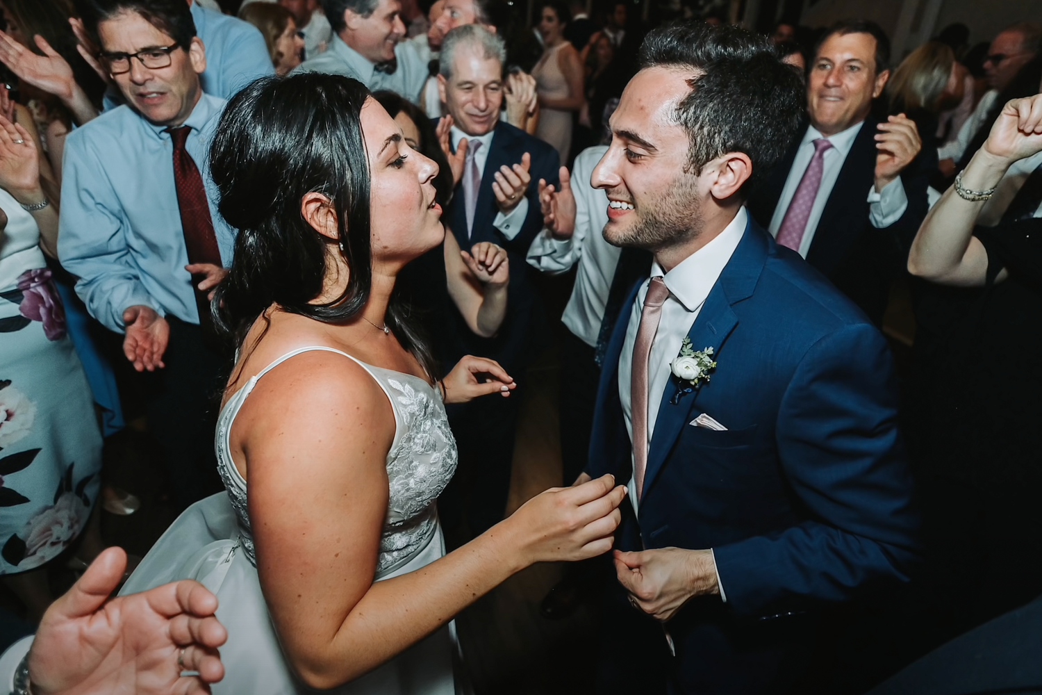 Dynamic shot of wedding guests dancing and celebrating at a lively reception.