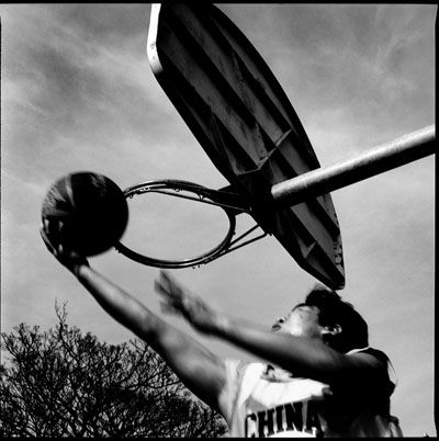 Black and white sequence showing basketball hoop and backboard against cloudy sky.