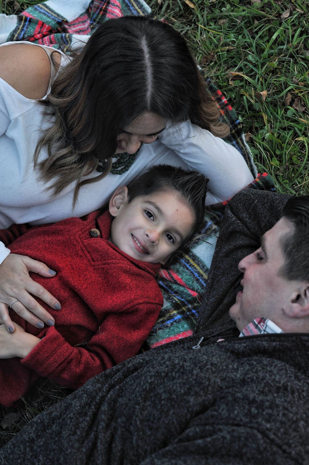 Family of 3 laying down in grass