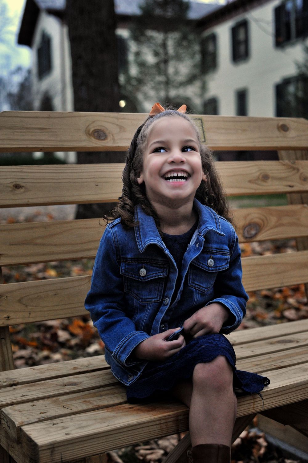 Girl laughing, wood bench in wooded setting