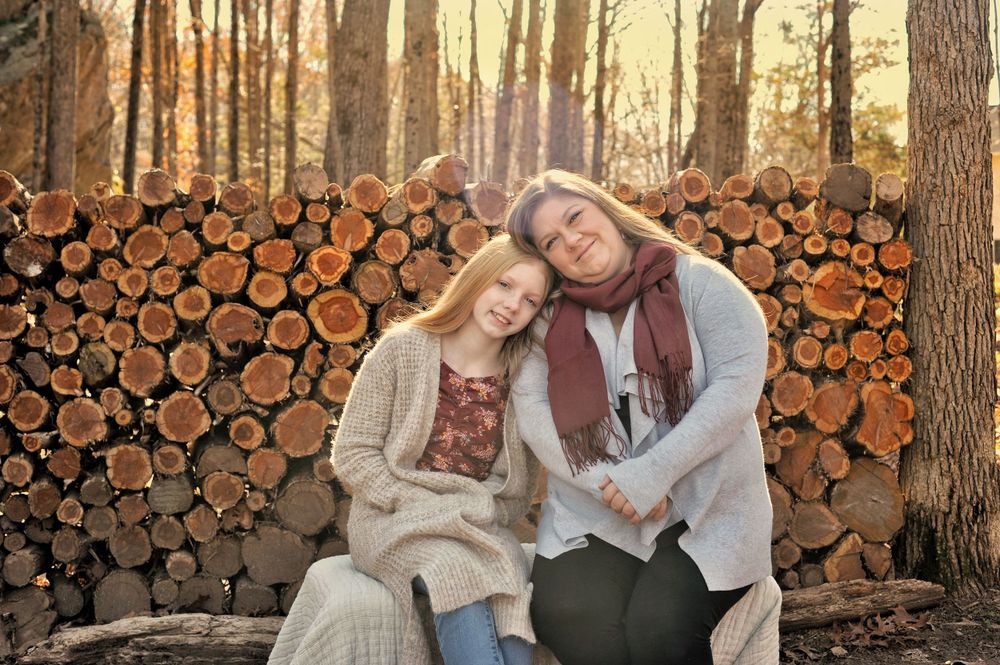 Mother and daughter at golden hour, wood round wall