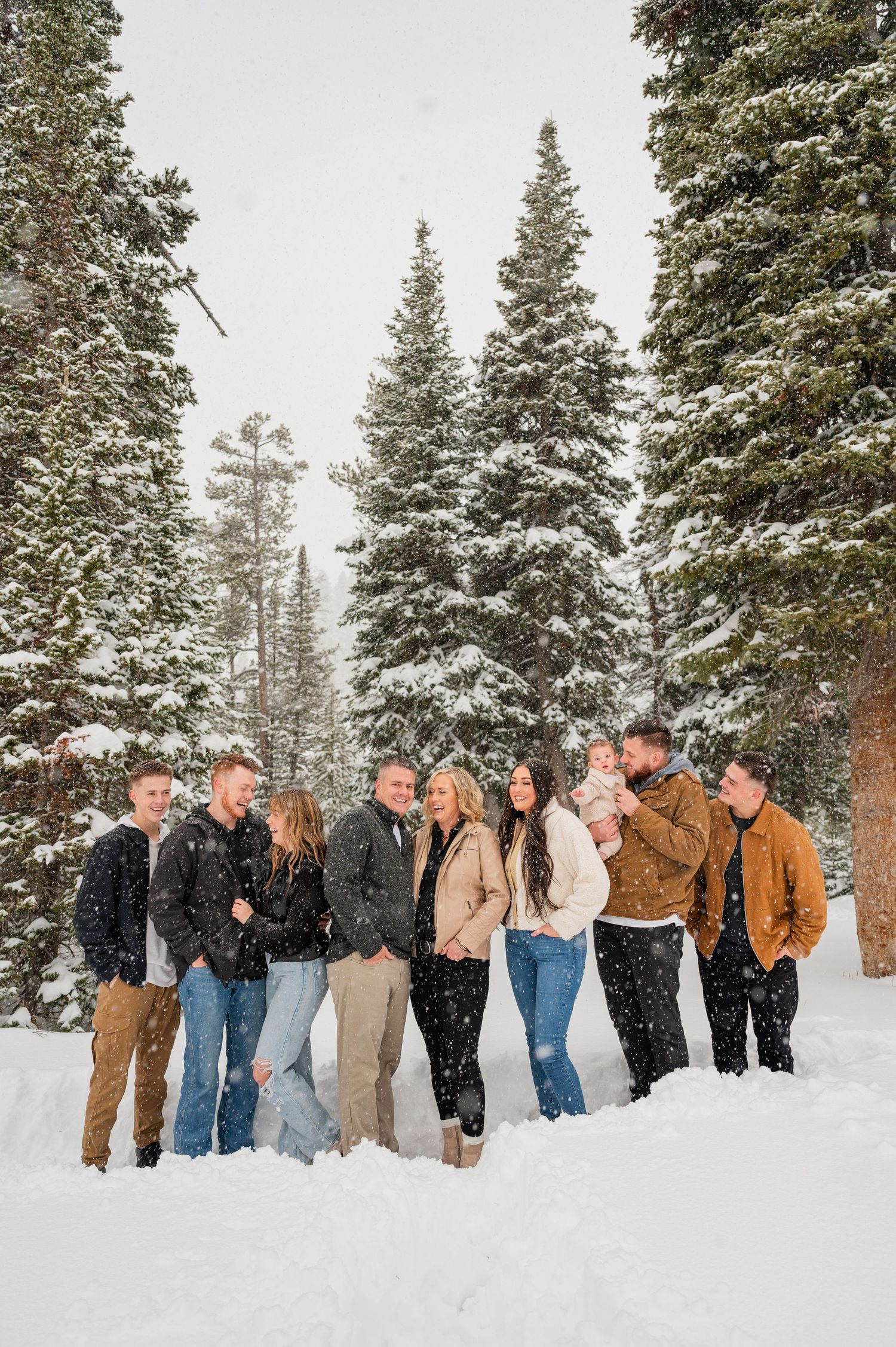 Group of friends pose together in a snow-covered mountain forest.