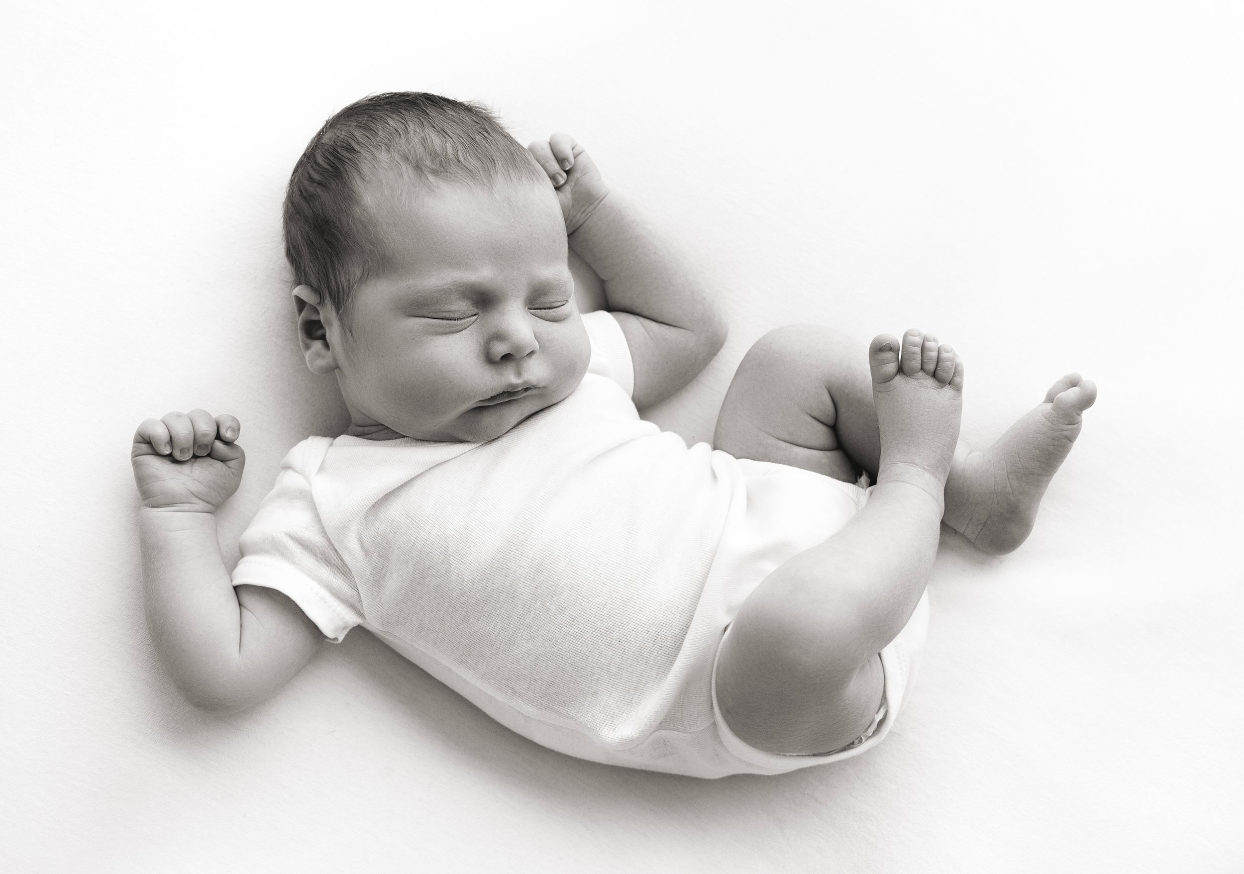 baby wears a simple white onesie during his first photoshoot in Victoria BC