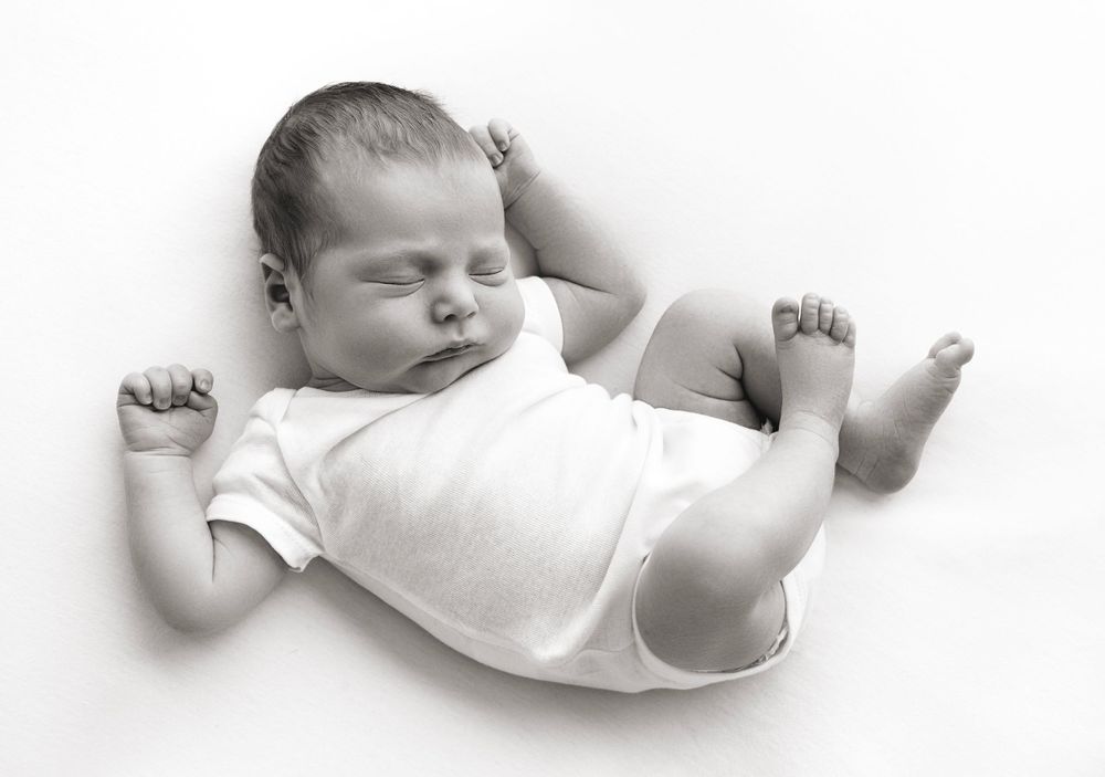 baby wears a simple white onesie during his first photoshoot in Victoria BC