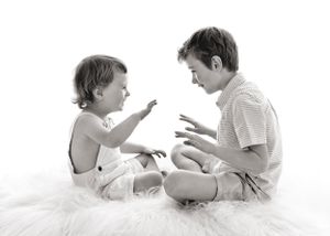 two brothers play a game of rock scissors paper during family photos