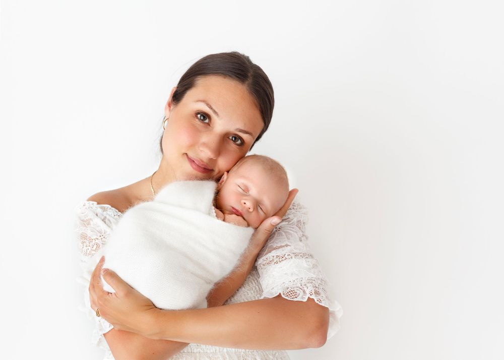 mama cradles her baby in her arms and snuggles her cheek