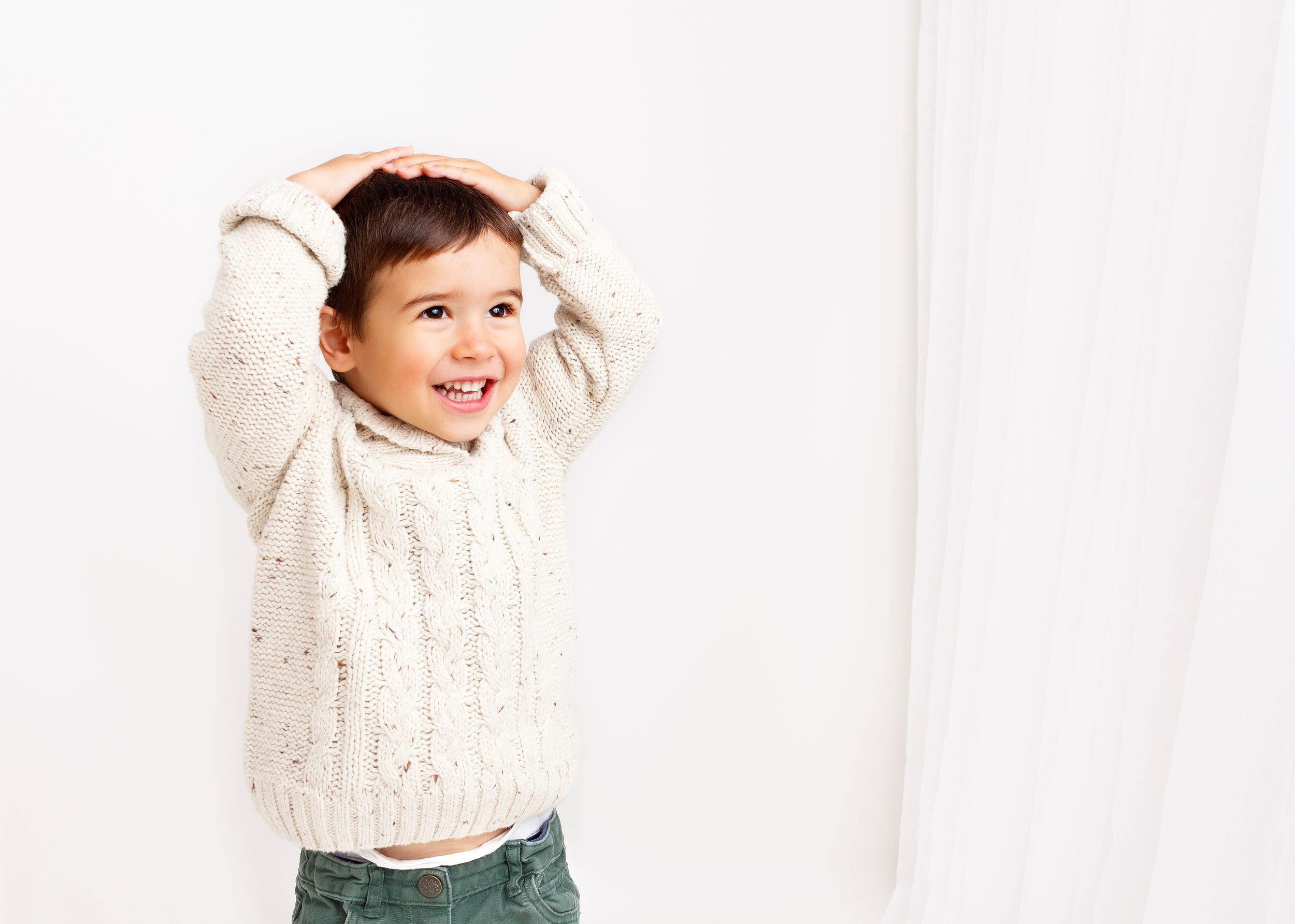 toddler giggles as he touches his head in a game of "Simon Says"