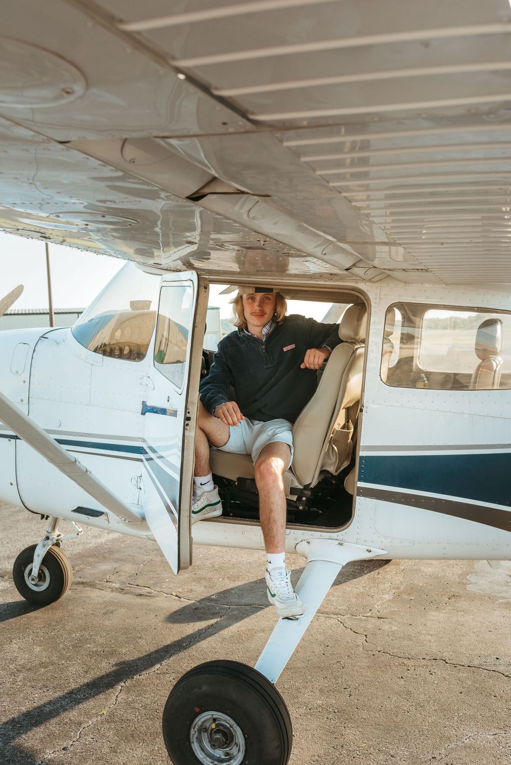 Playful engagement photos taken underneath and around a small private airplane.