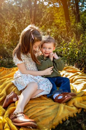 Children sitting on yellow blanket outdoors during golden hour.
Janesville, WI
Brodhead, WI