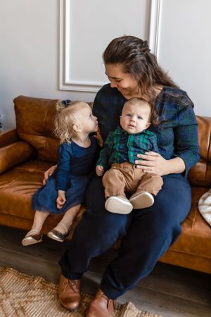 A candid family moment captured on a brown leather couch with matching coordinated navy and plaid outfits. Janesville, WI
Brodhead, WI