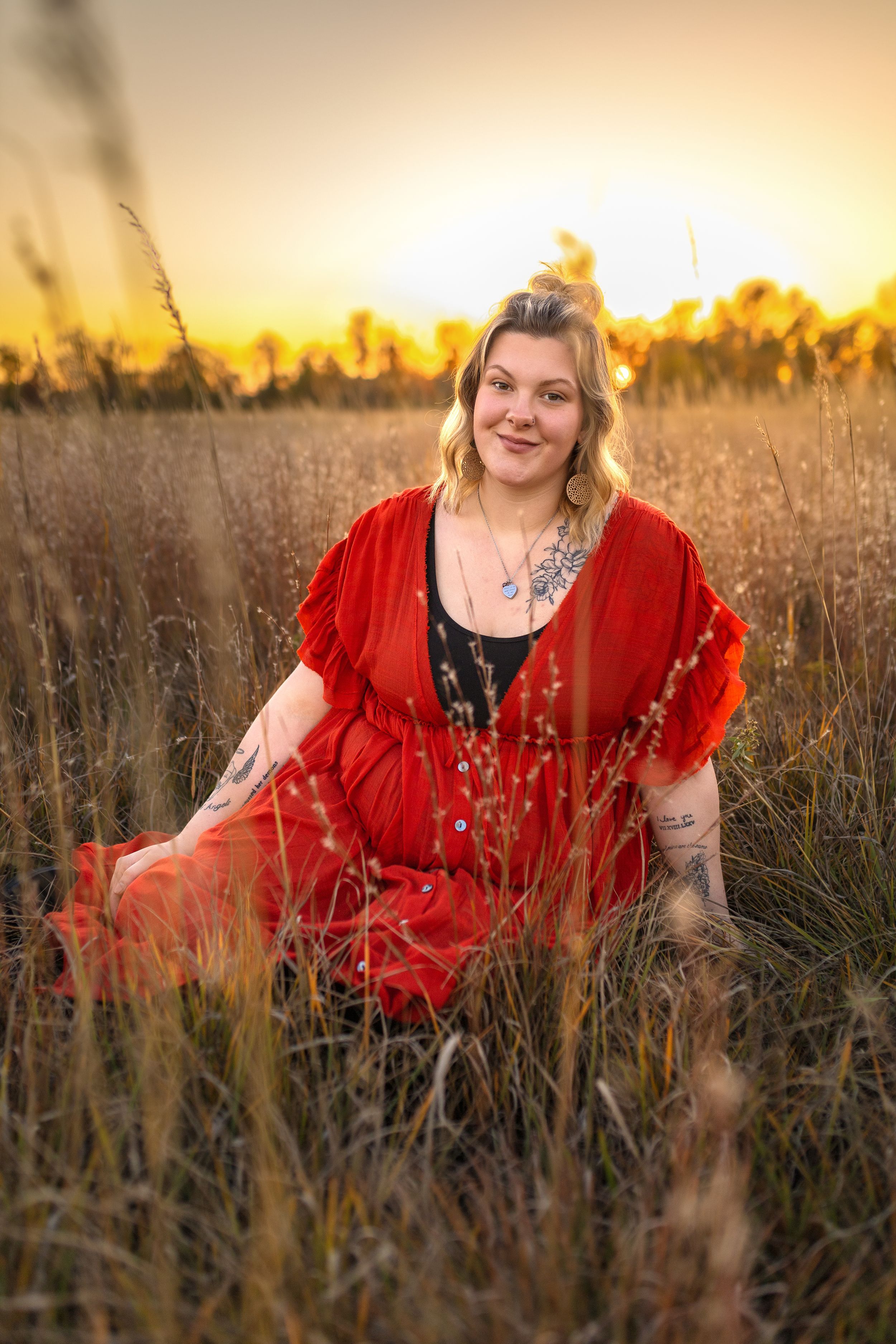 Dreamy maternity portrait in red dress amid tall grass during golden hour sunset.
Janesville, WI
Brodhead, WI