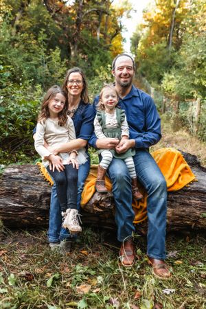 Small group seated on fallen log in wooded area with autumn foliage and orange blanket.
Janesville, WI
Brodhead, WI