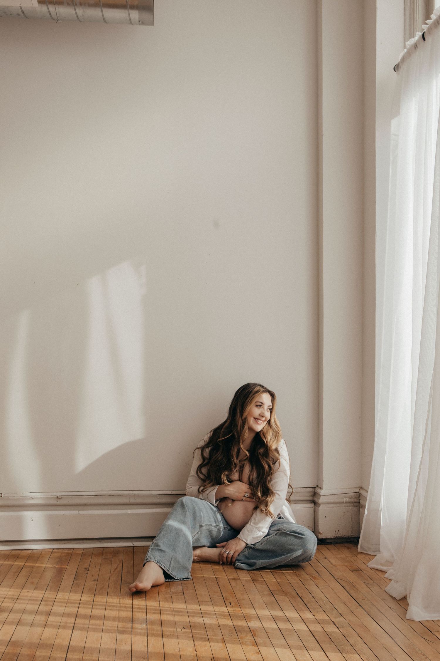 Artistic portrait series showing person in casual wear lounging by window.