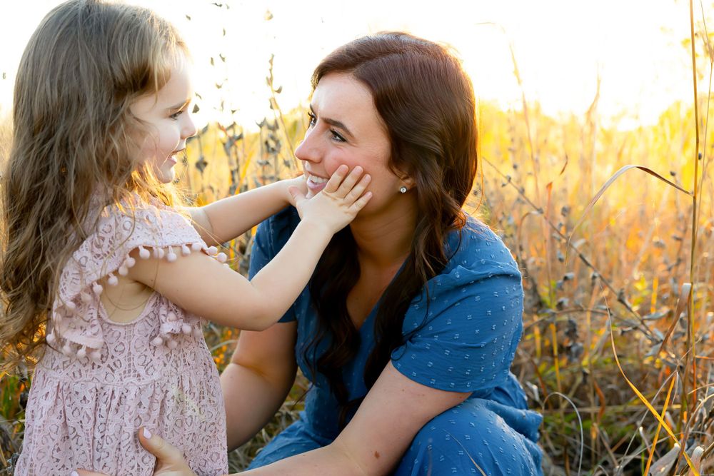 Heartwarming interaction between two people in a sun-drenched field.